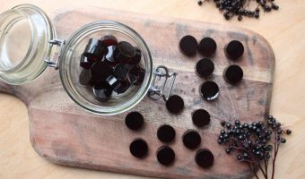 An overhead shot of elderberry gummies on a wooden cutting board.