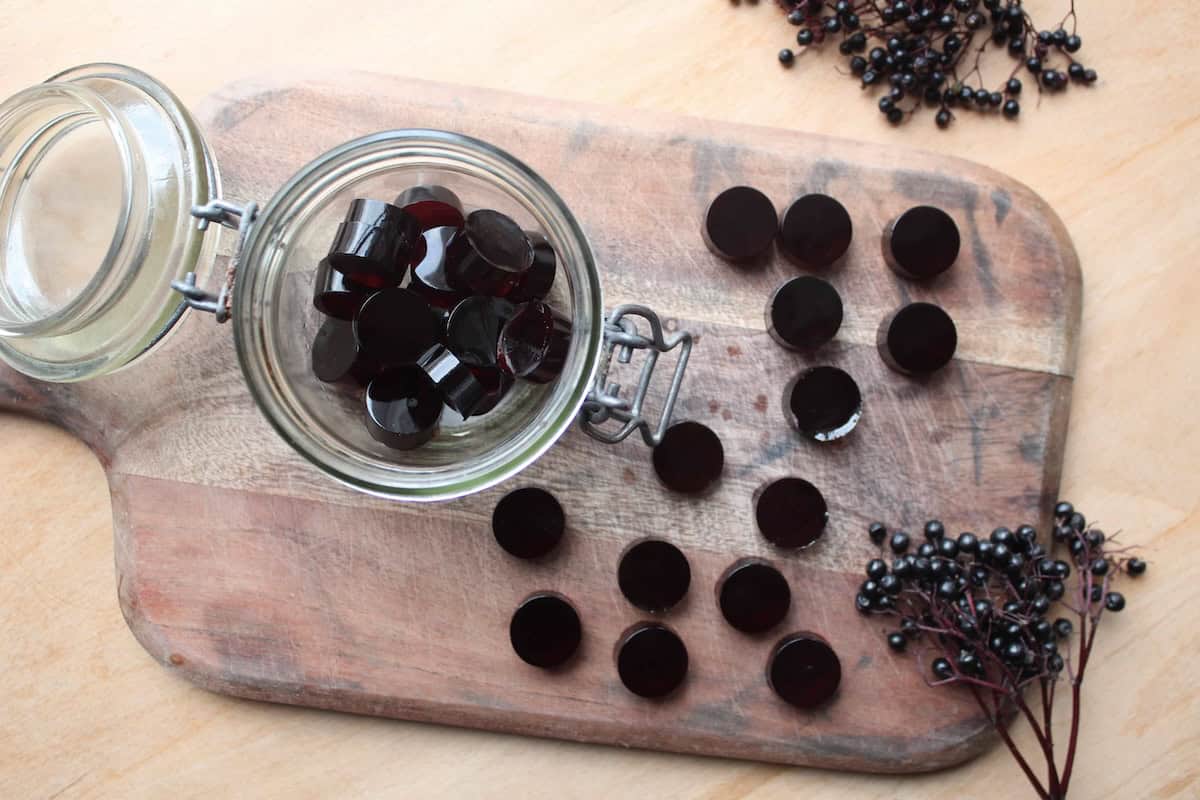 An overhead shot of elderberry gummies on a wooden cutting board.