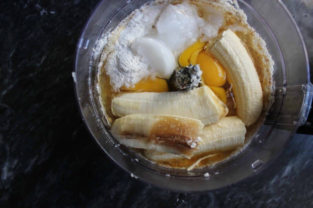 Bananas, coconut oil, eggs, and baking powder in a food processor