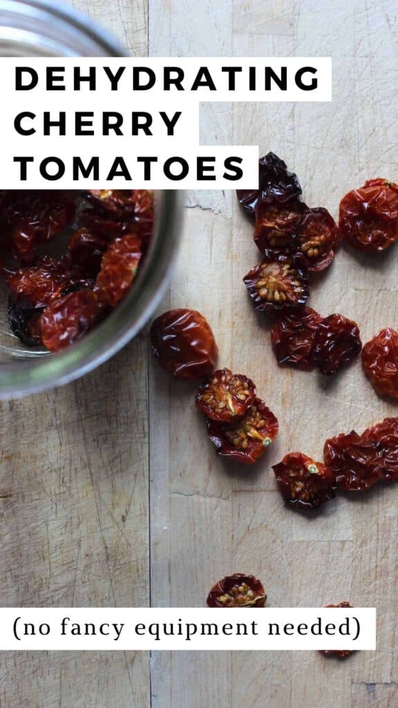 An overhead shot of dehydrated cherry tomatoes on a wooden cutting board with a small glass mason jar full of dehydrated cherry tomatoes next to it.