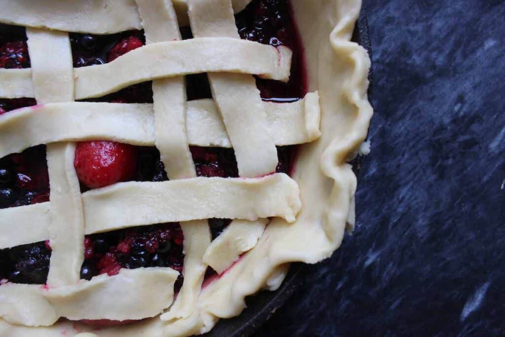 A close up shot of homemade pie with berries before baking.
