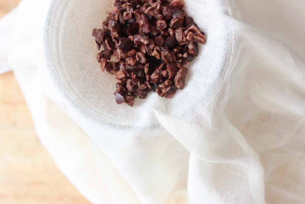 An overhead shot of raw cacao nibs in cheesecloth.