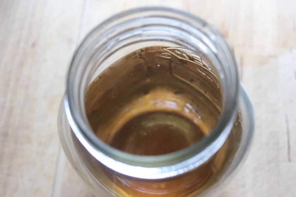 An overhead shot of shiitake dashi broth in a glass mason jar.