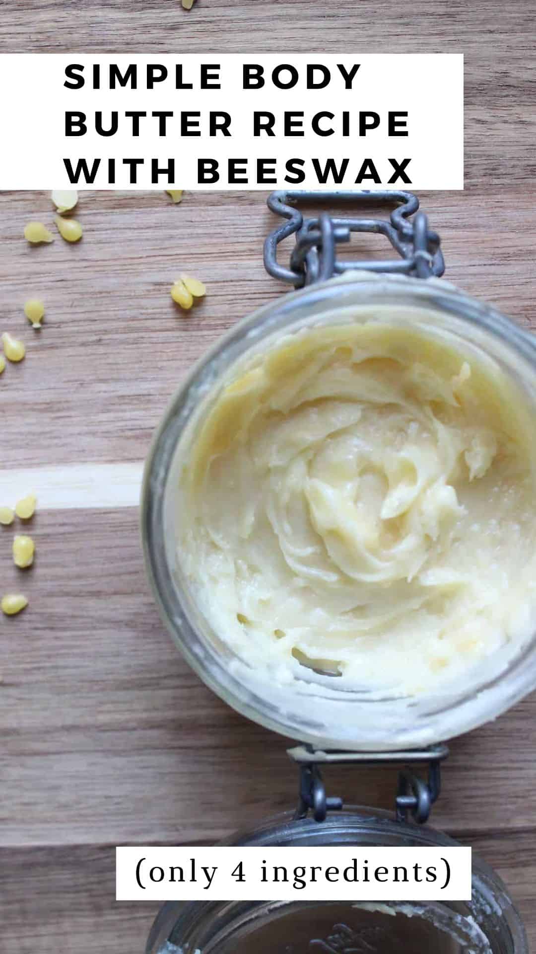 An overhead shot of ﻿﻿beeswax, coconut oil, shea butter, and cocoa butter whipped into a body butter in a glass jar on a light countertop. There are beeswax pellets beside the jar.