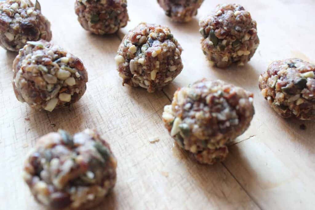 A close up shot of bee bread date balls on a light countertop.