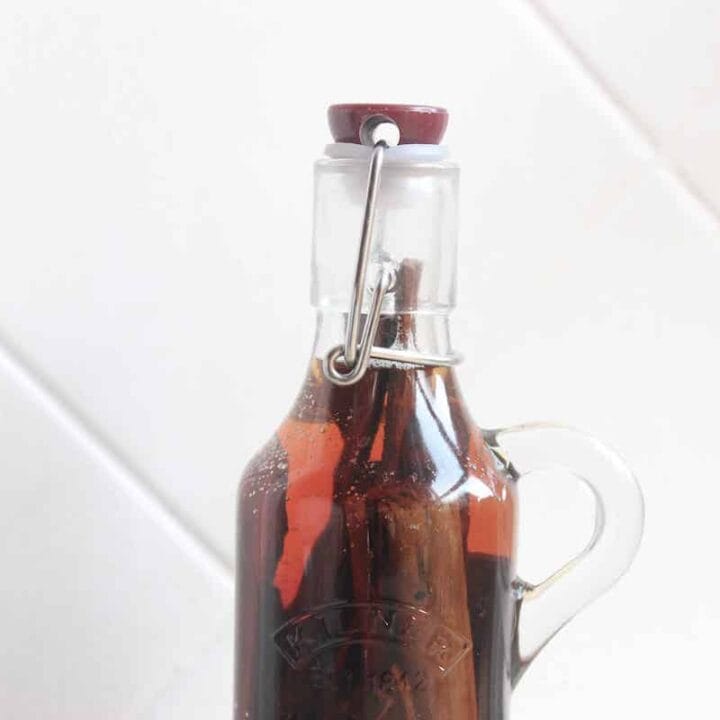 A close up of homemade cinnamon extract in a glass bottle.