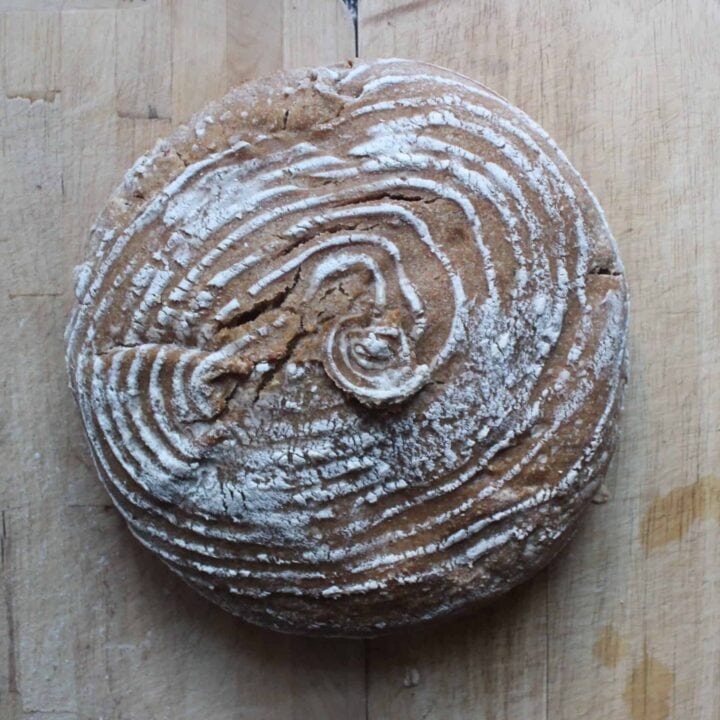An overhead shot of a loaf of Parmesan Sourdough Bread with a spiral design on a light countertop.