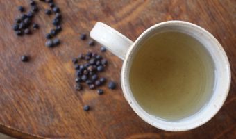 An overhead shot of juniper berry tea in a white mug.
